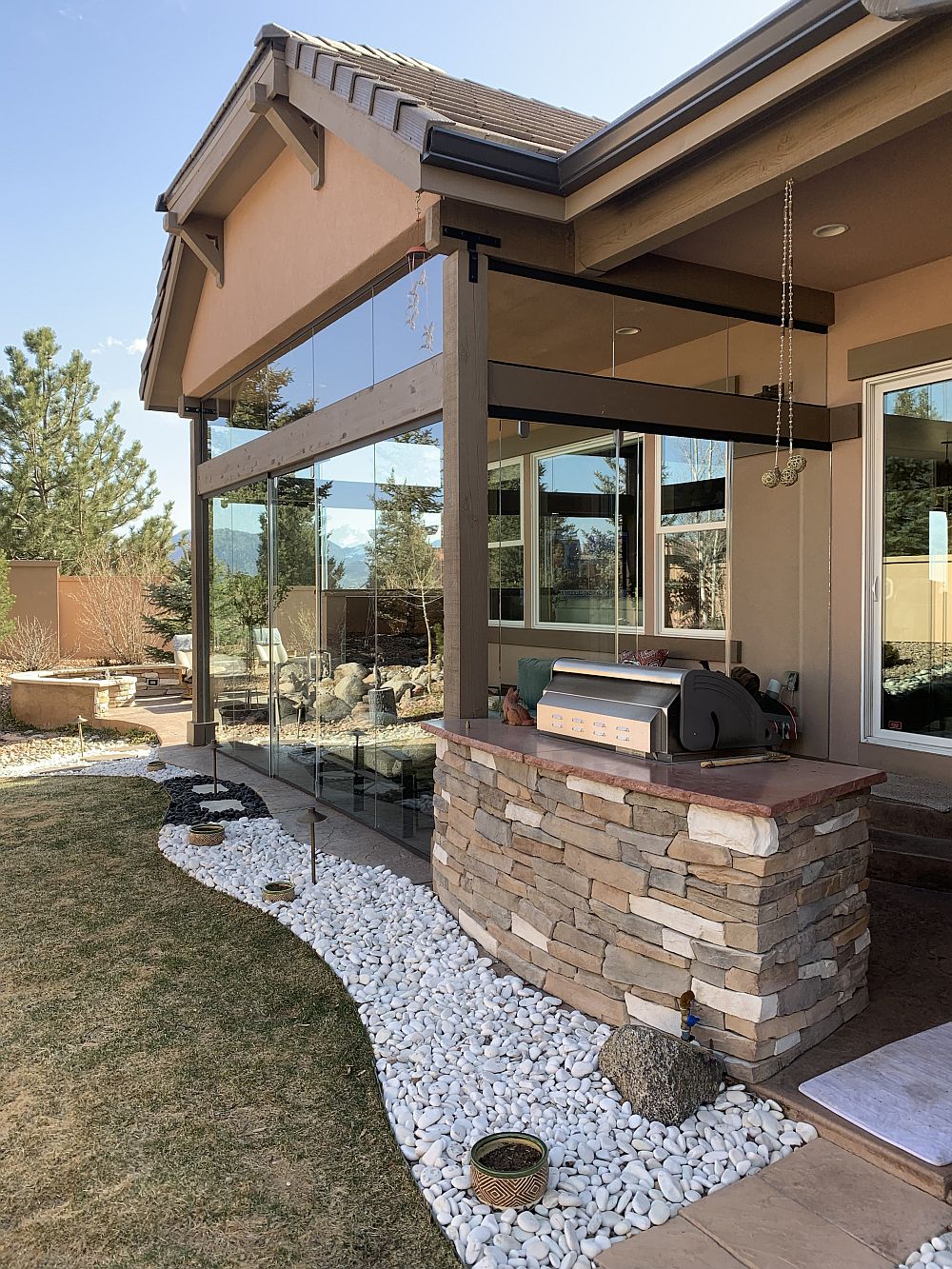 Glass enclosed patio with a built-in grill just outside the door