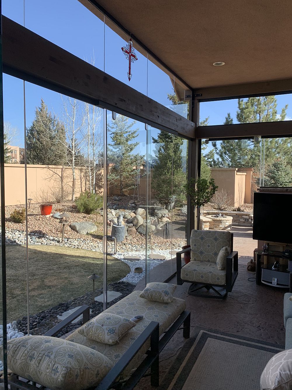 Glass enclosed patio turned into full 3-season room with couches and tv