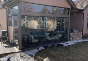 Covered patio turned into a 3 season room with glass walls and sliding glass doors.