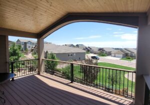 Composite deck with metal panel railing and deck cover featuring a tongue and groove pine vaulted ceiling.