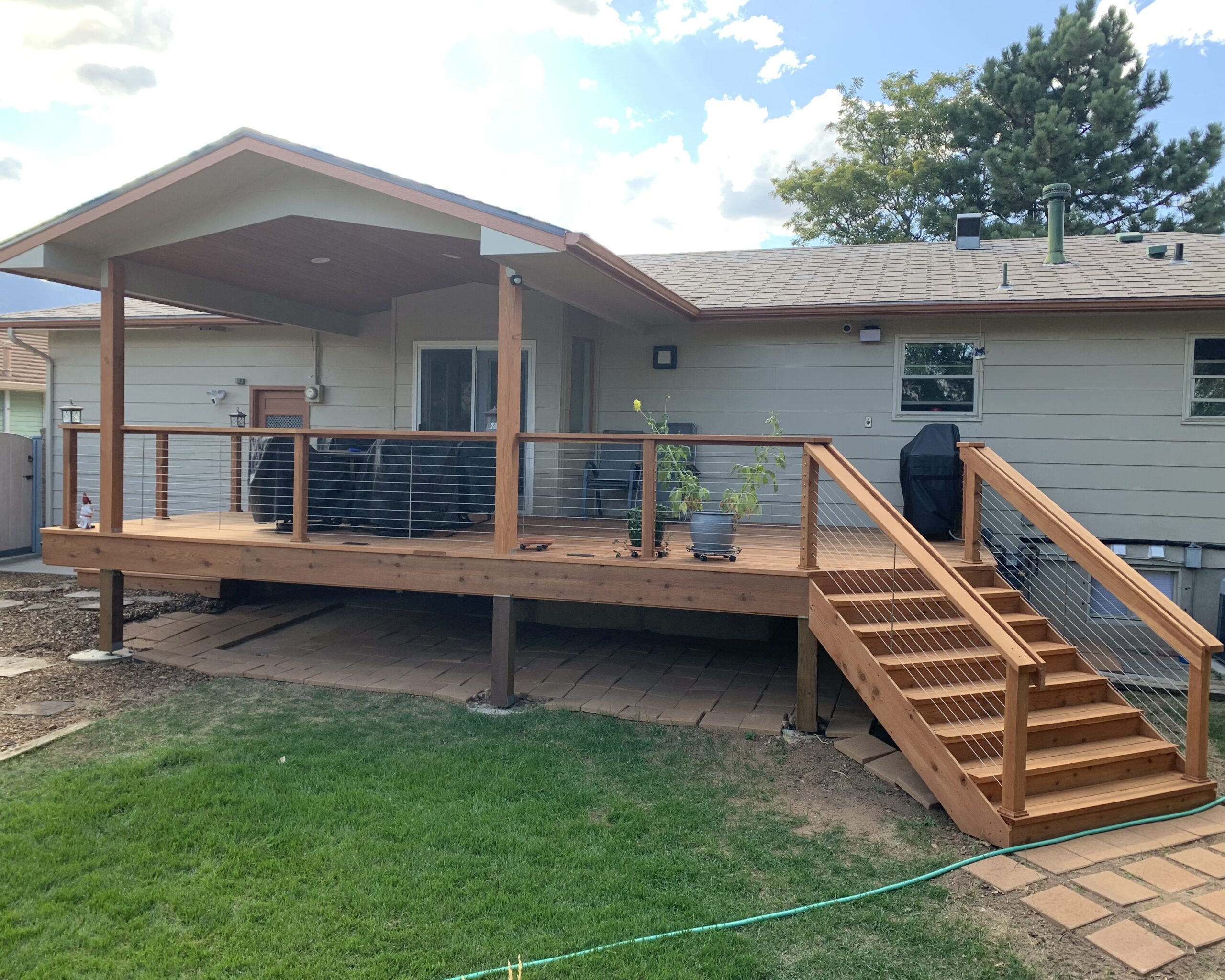 Redwood deck with gabled deck cover and custom designed wood and stainless steel cable railing.