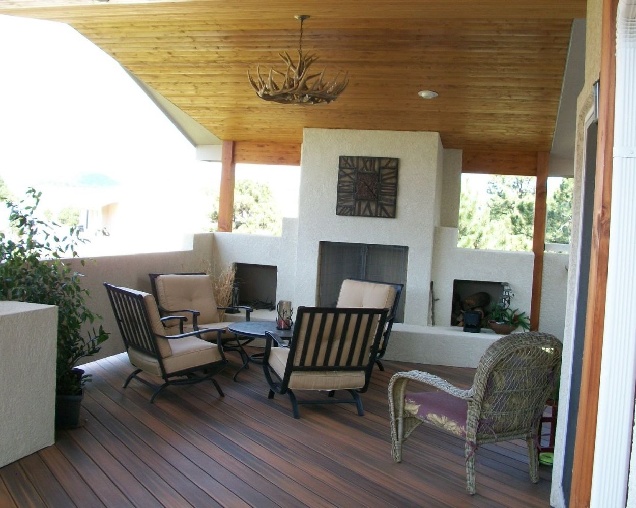 Composite deck with gabled deck cover and custom built, wood-burning stucco fireplace
