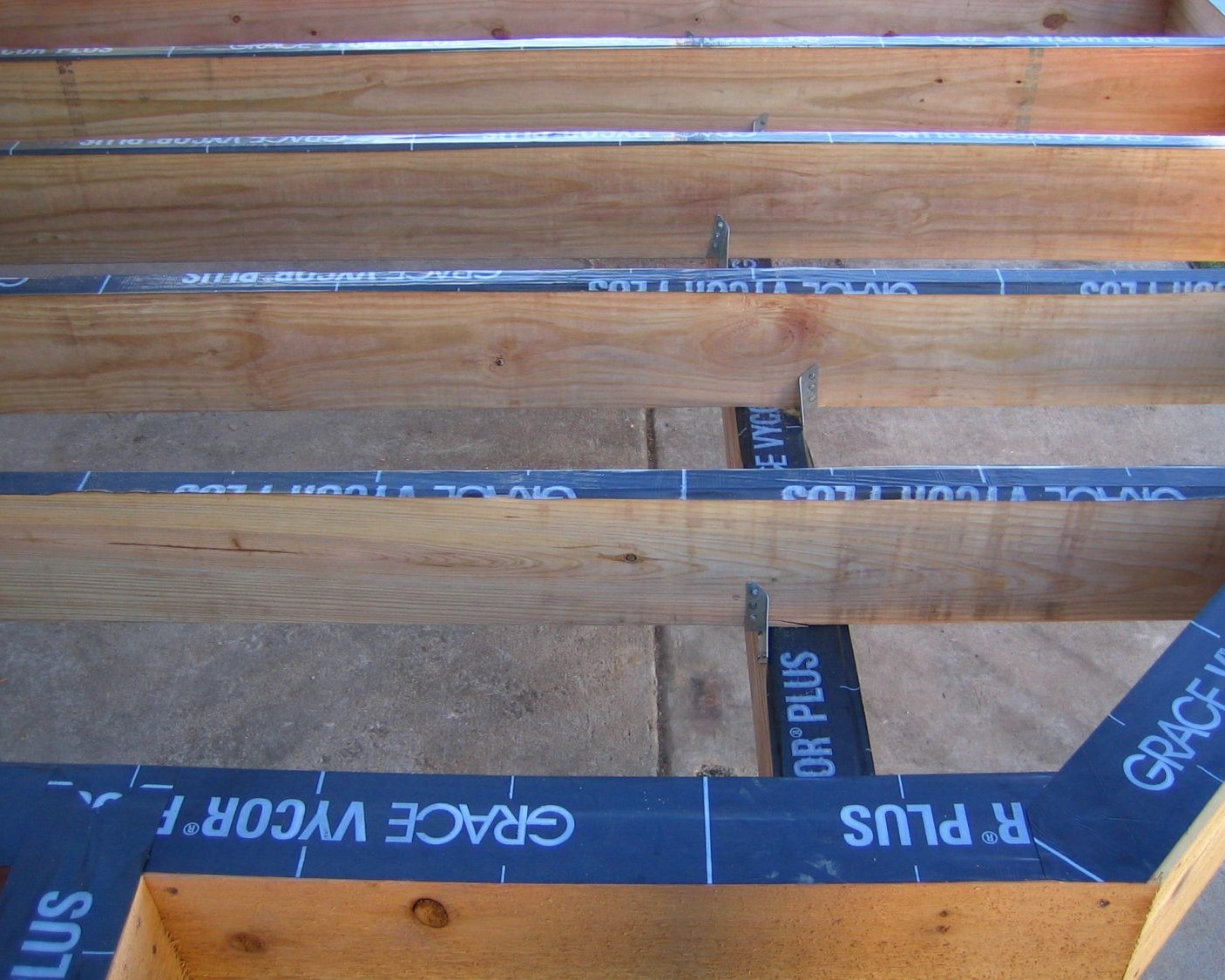 Joist protector tape installed on wood deck frame to prevent water damage.