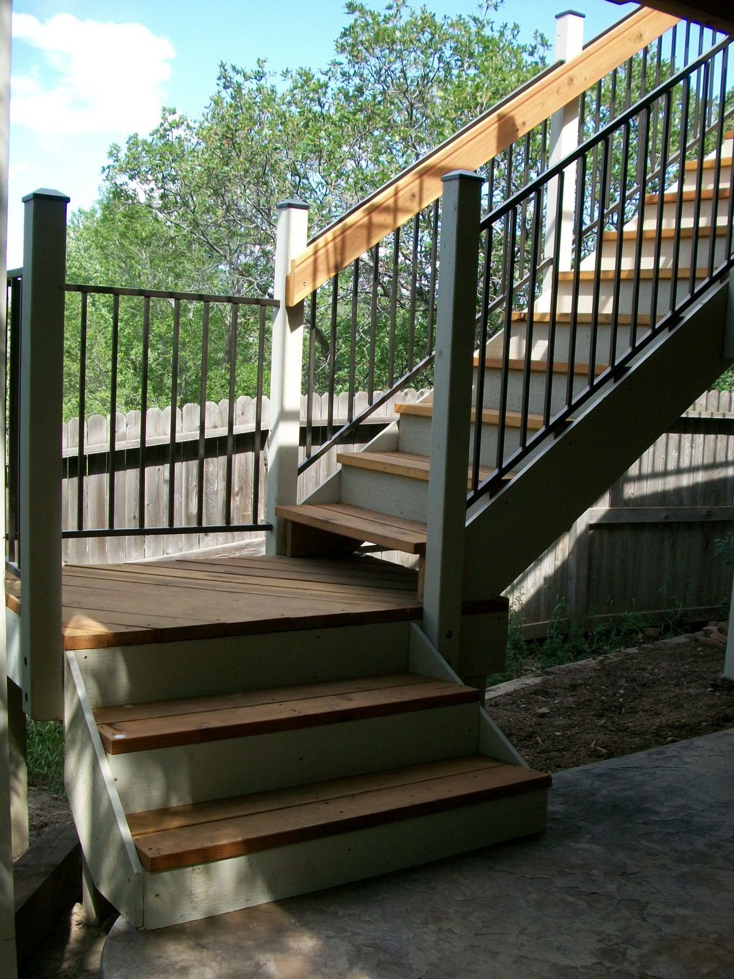 3'-wide closed deck stairs with a 90-degree turn landing, wood railing posts and handrail with metal baluster panels between the posts.