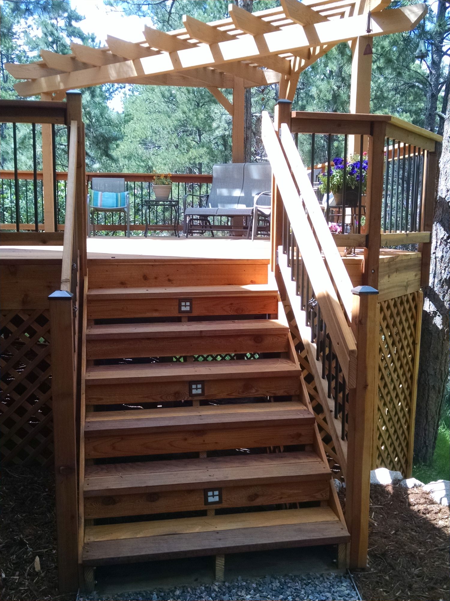 Redwood deck with 3'-wide partially closed steps. The partial risers have step lights installed.