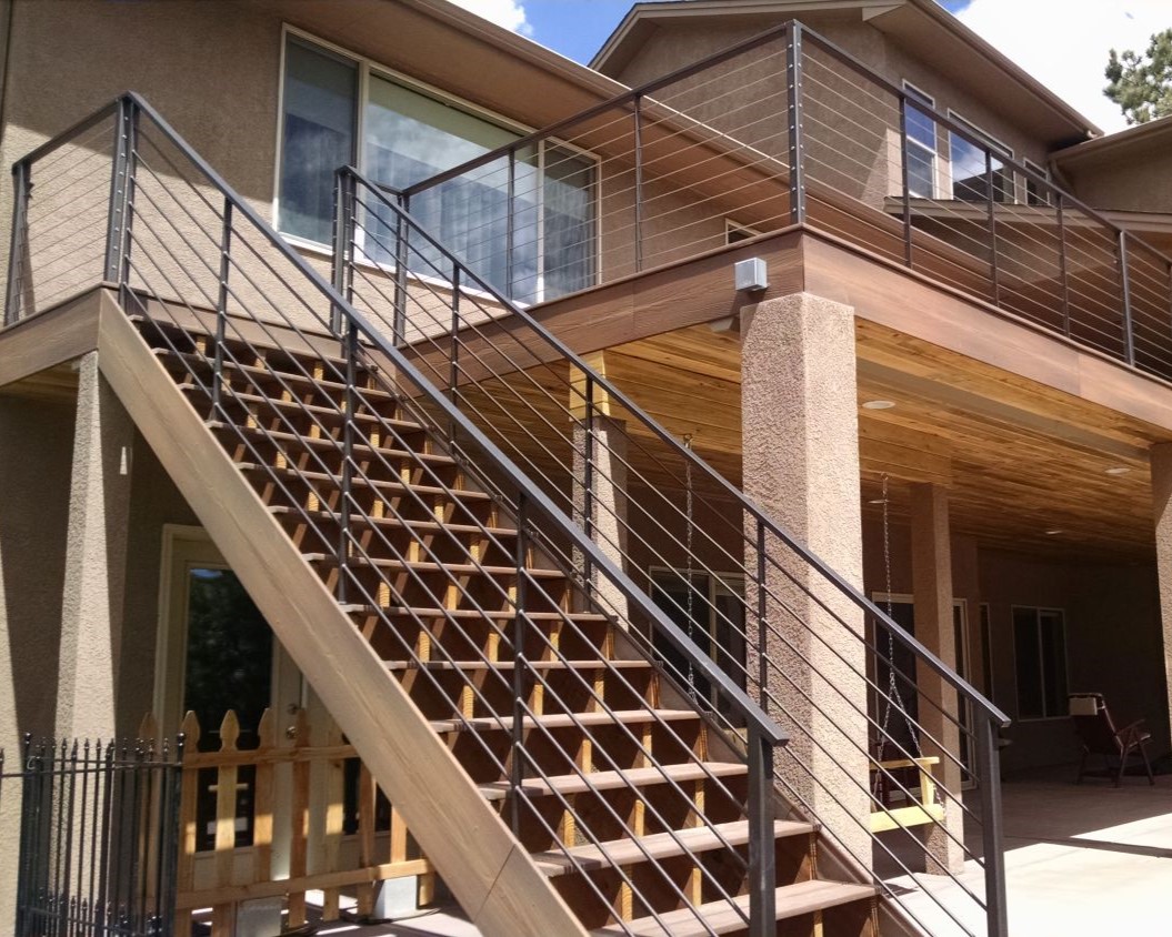 Large composite deck with a custom metal and steel cable railing. The stairs are 4'-wide open steps.