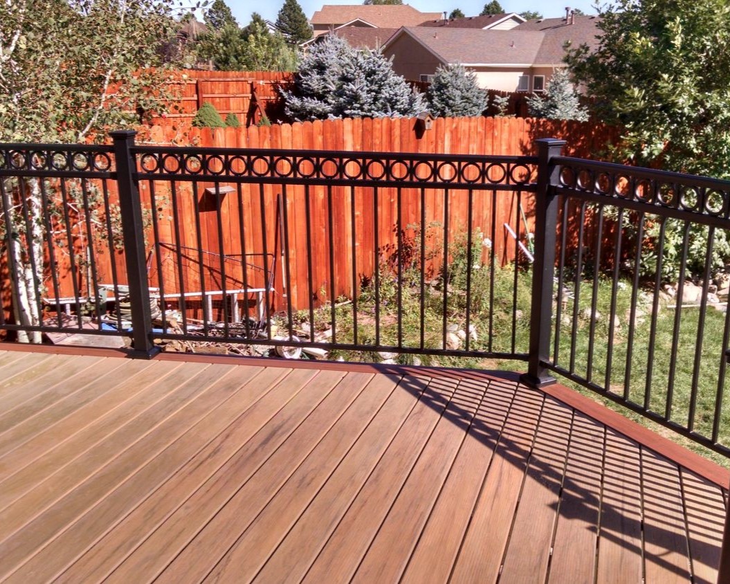 Composite deck with the boards laid at 90-degrees. Black metal railing with a ring top accent panel.
