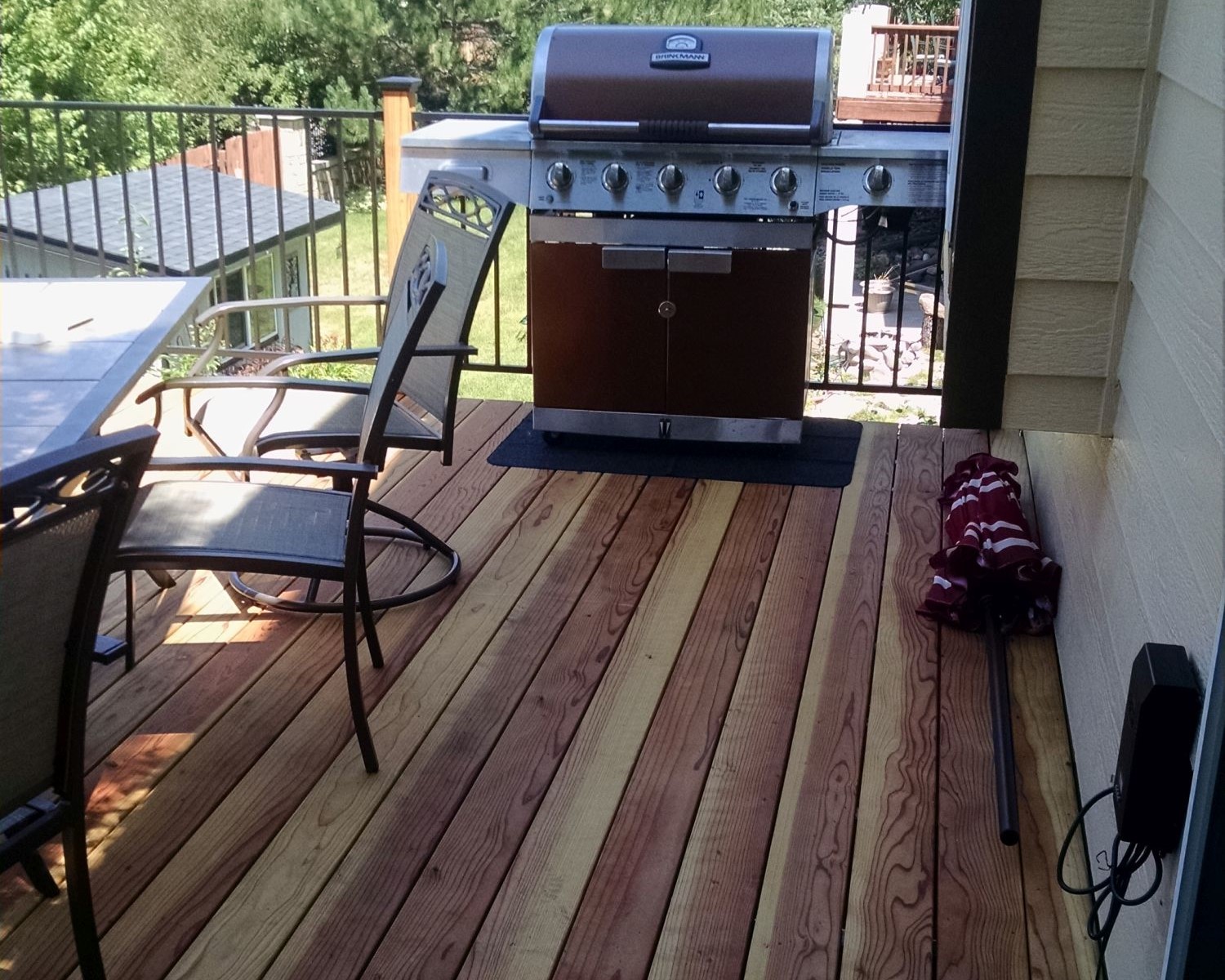 B-Grade redwood deck with the boards laid at 90-degrees. The railing is wood posts with metal panels between them.