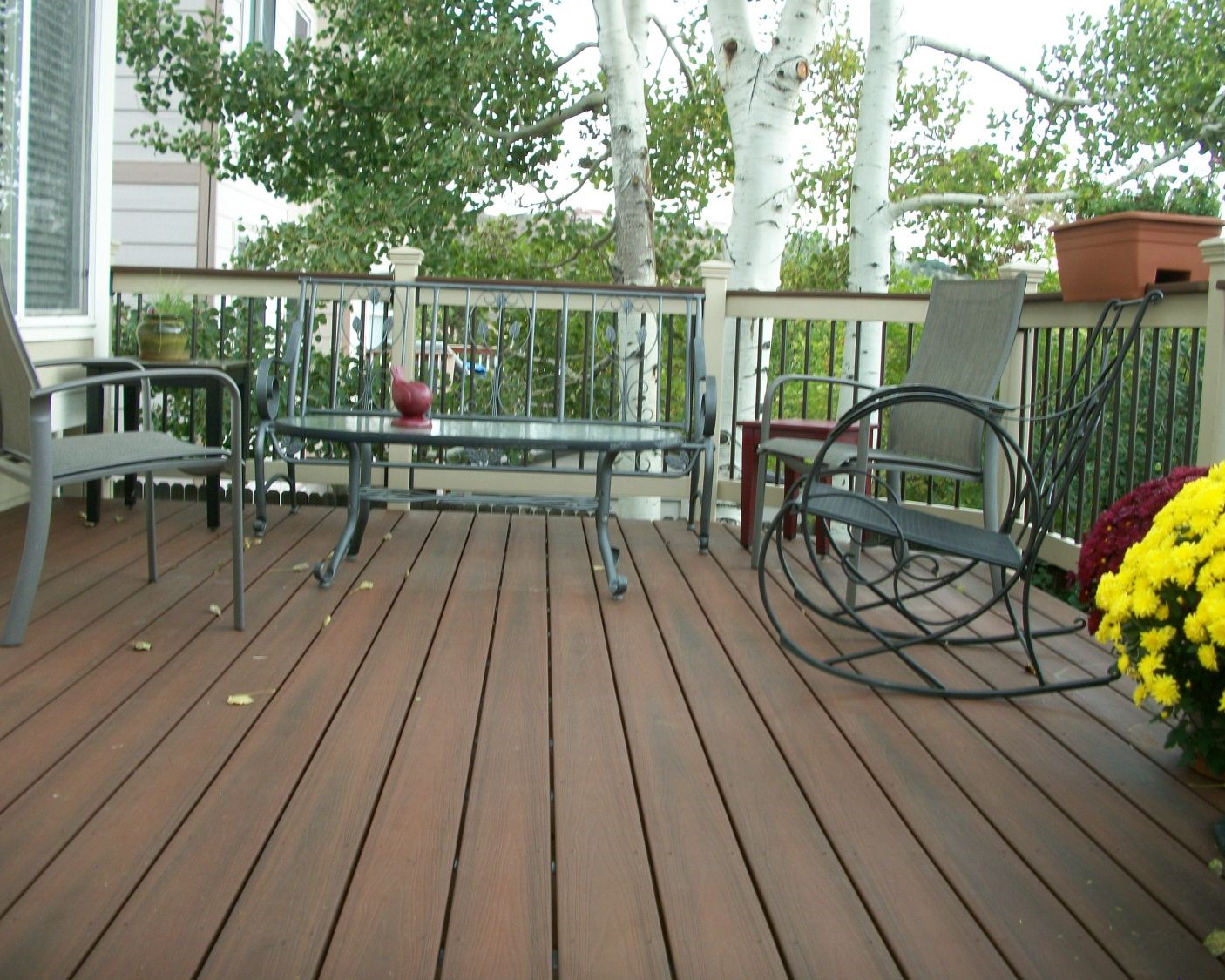 90-degree composite decking and railing with composite components and black metal balusters.