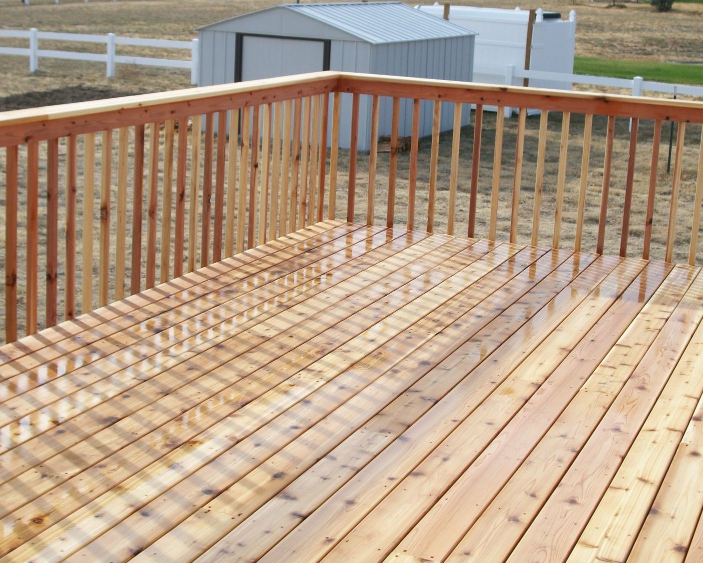 Gorgeous Cedar deck with a picket fence railing and drink cap.