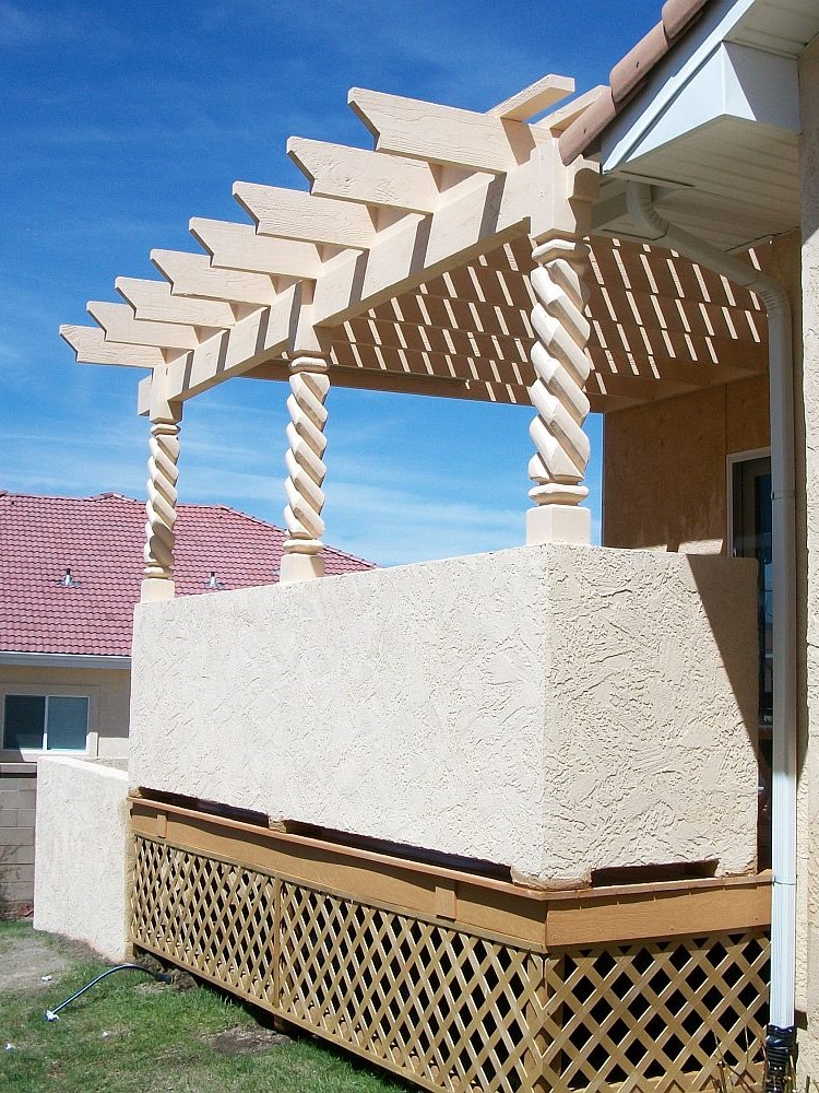 Custom deck with stucco half-walls and a pergola with twisted posts