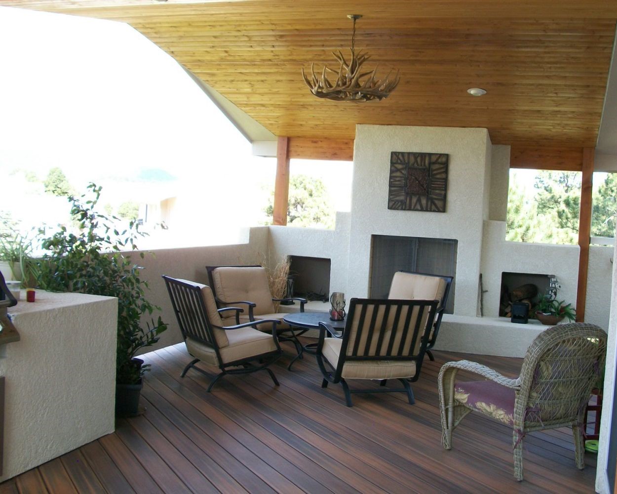 Amazing outdoor living space with composite deck, gabled deck cover, and stucco wood-burning fireplace.