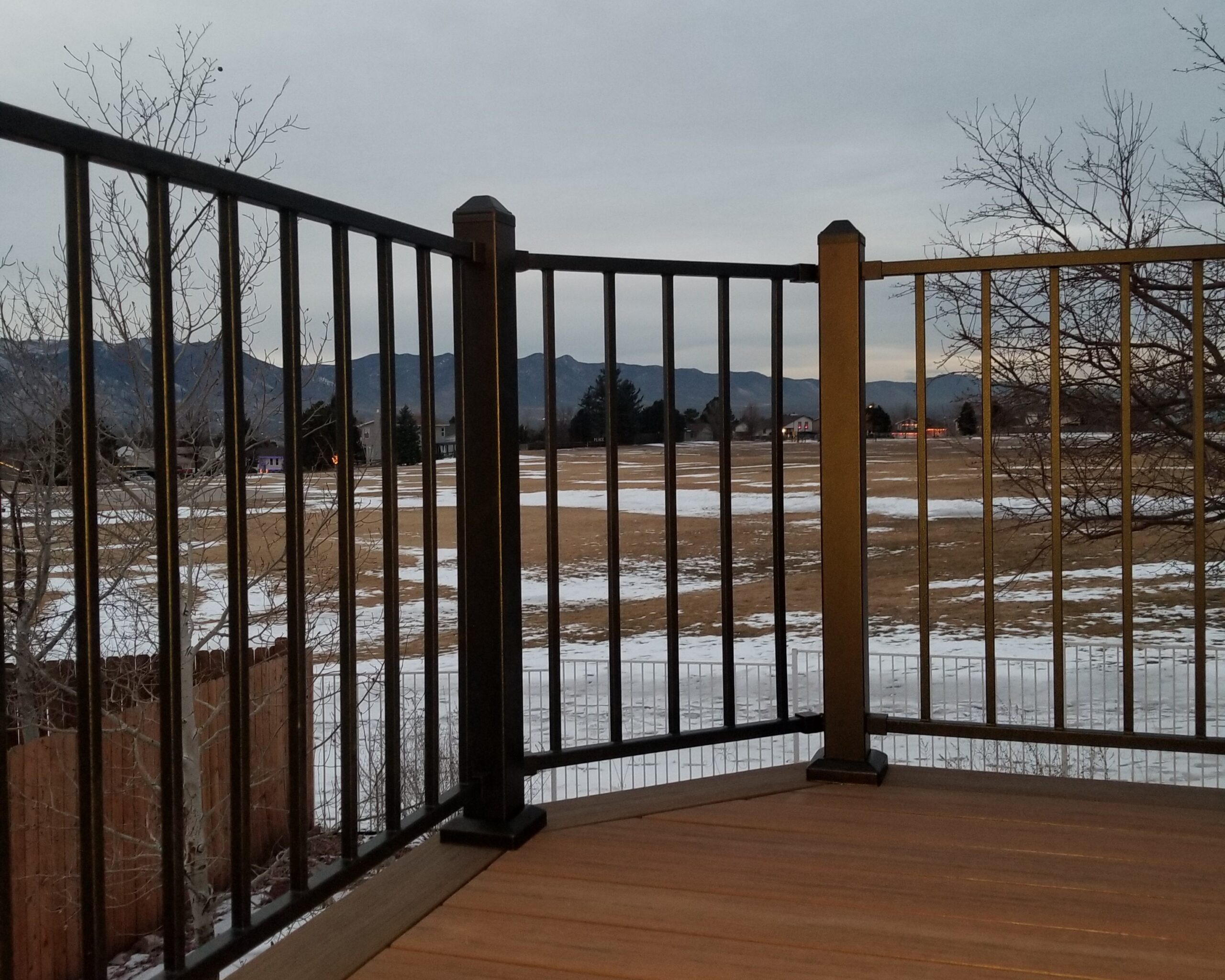 A composite deck with single picture frame border and a metal panel railing system with 2