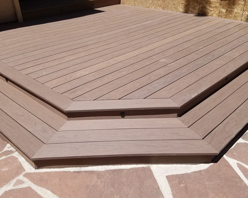 Ground-level composite deck with a single wrap-around stair.