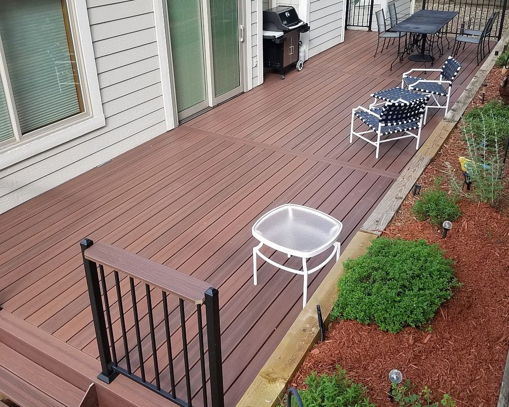 Composite deck with steel deck frame. The railing is black metal with a drink cap.
