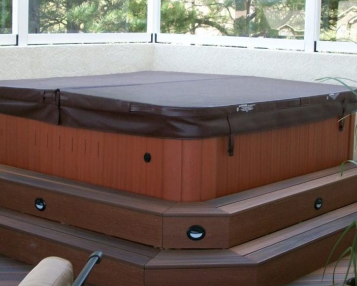 Composite steps that surround a hot tub with Estes step lights installed on the three sides.