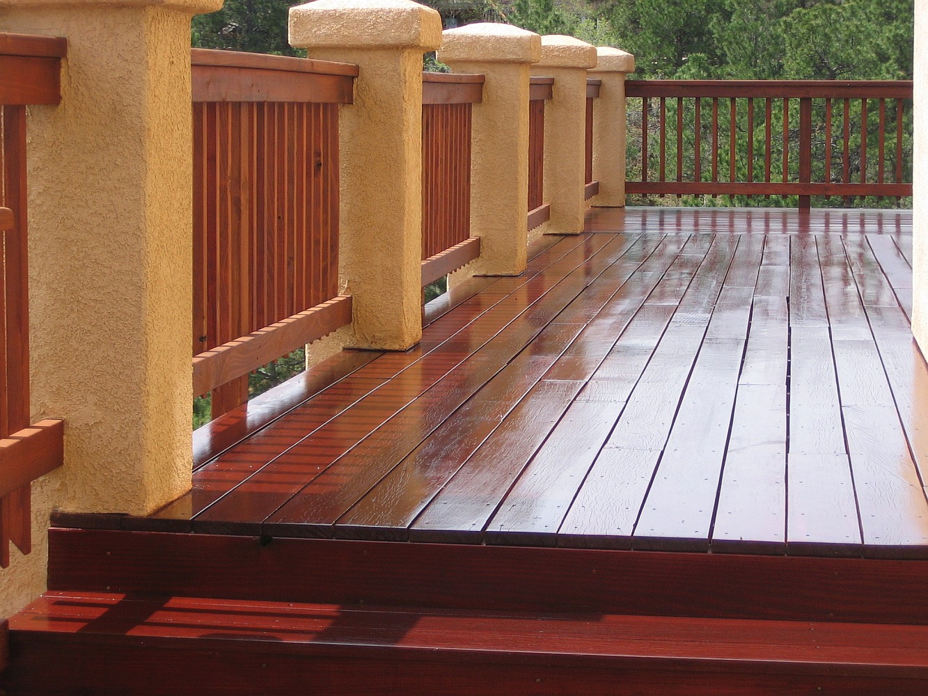 Cumaru hardwood deck with stucco columns and redwood snow fence railing