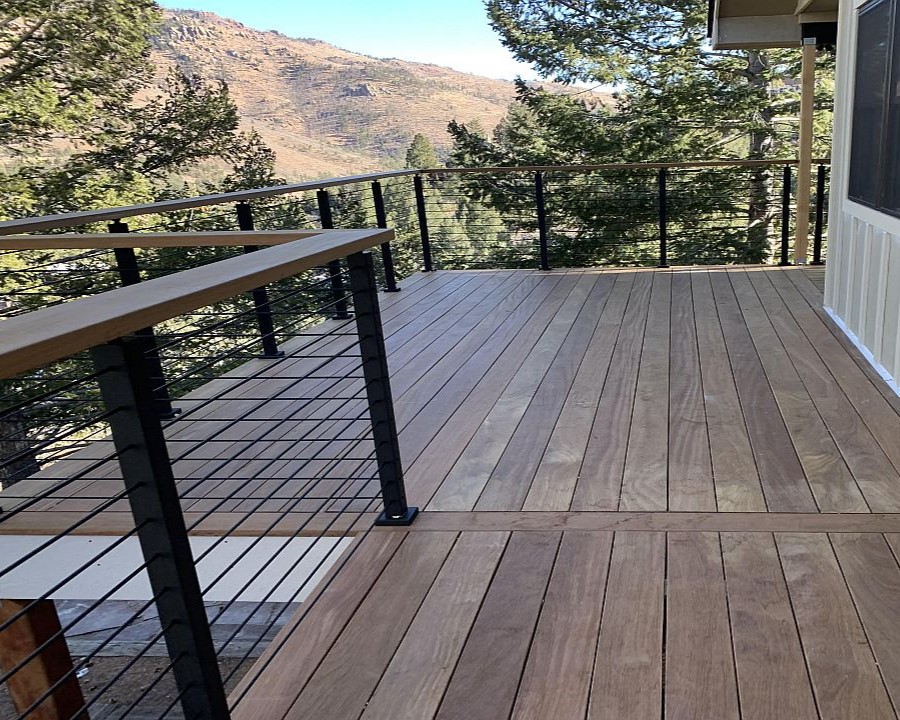 Cumaru hardwood deck with single dividing board. Custom railing with metal horizontal rods.