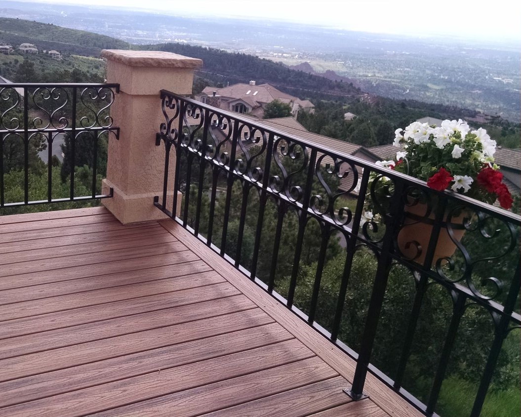Composite deck with a custom-designed and built wrought iron railing showcasing an elevated view of Colorado Springs