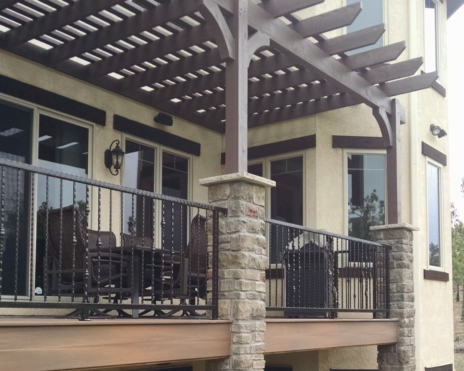 Custom-designed and built wrought iron railing on a composite deck with Cedar pergola.