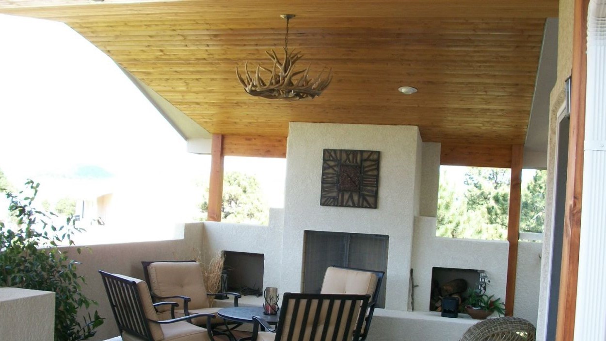 Vaulted ceiling deck cover in tongue and groove with recessed lights. Custom stucco, wood-burning fireplace