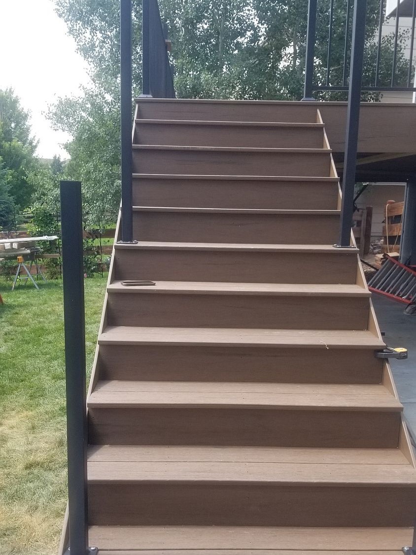 Deck stairs being built, but no railing has been installed yet.