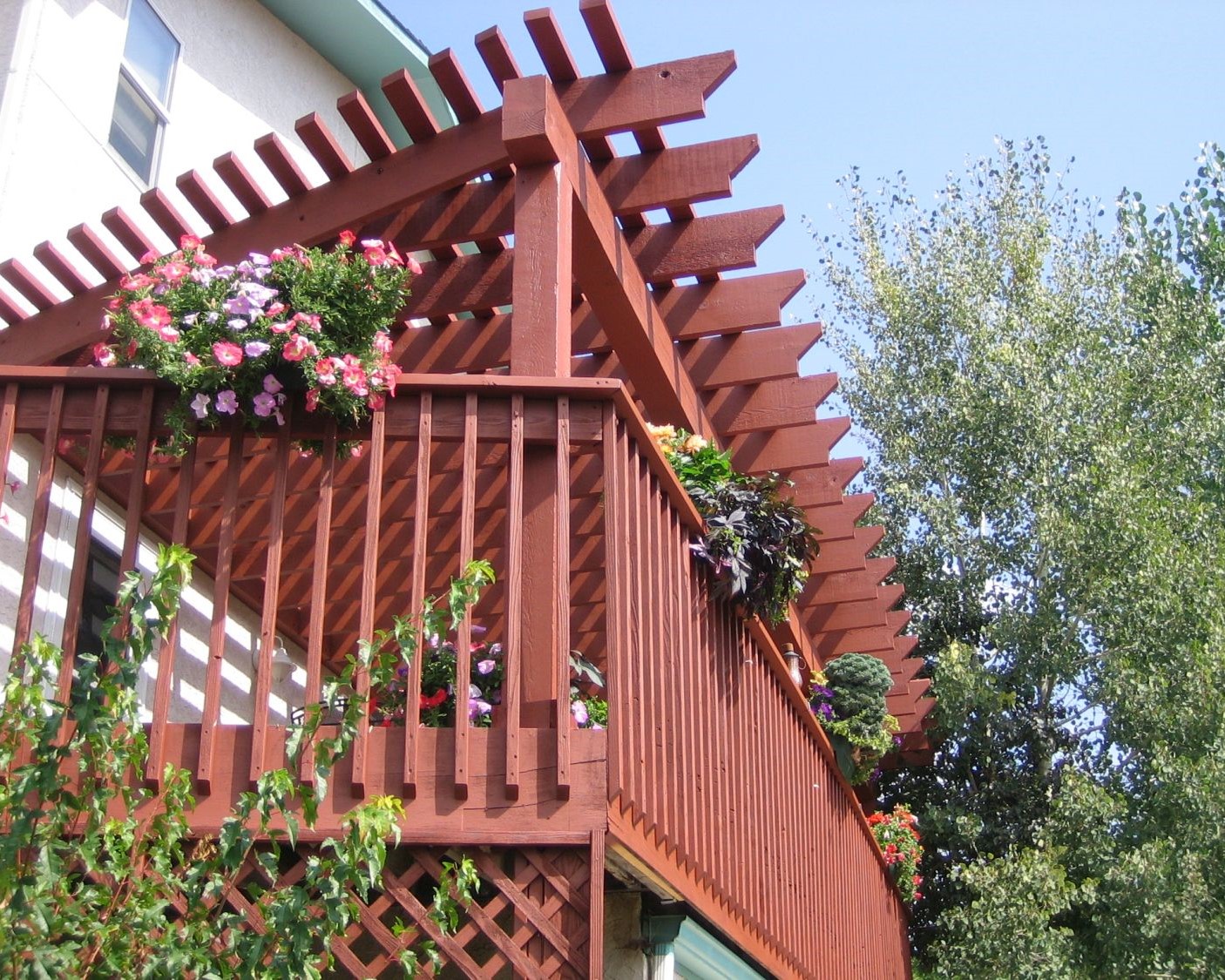 Redwood deck with picket fence railing and pergola that have been stained to match each other