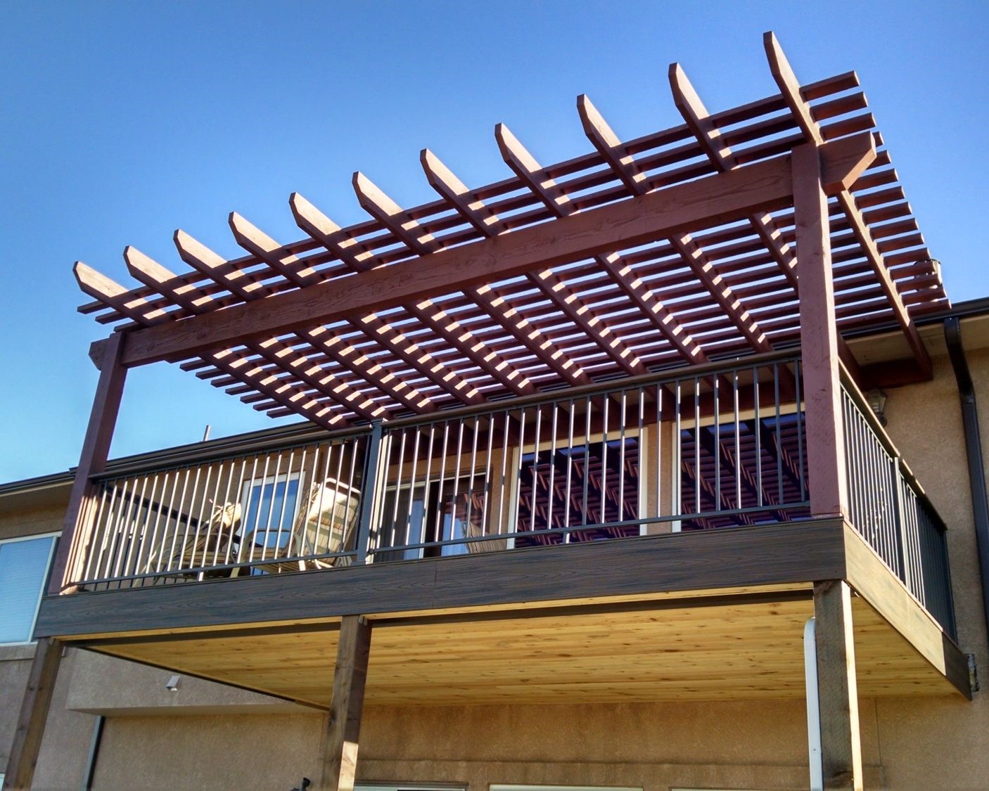 An elevated composite deck with cedar pergola and under deck drainage system.