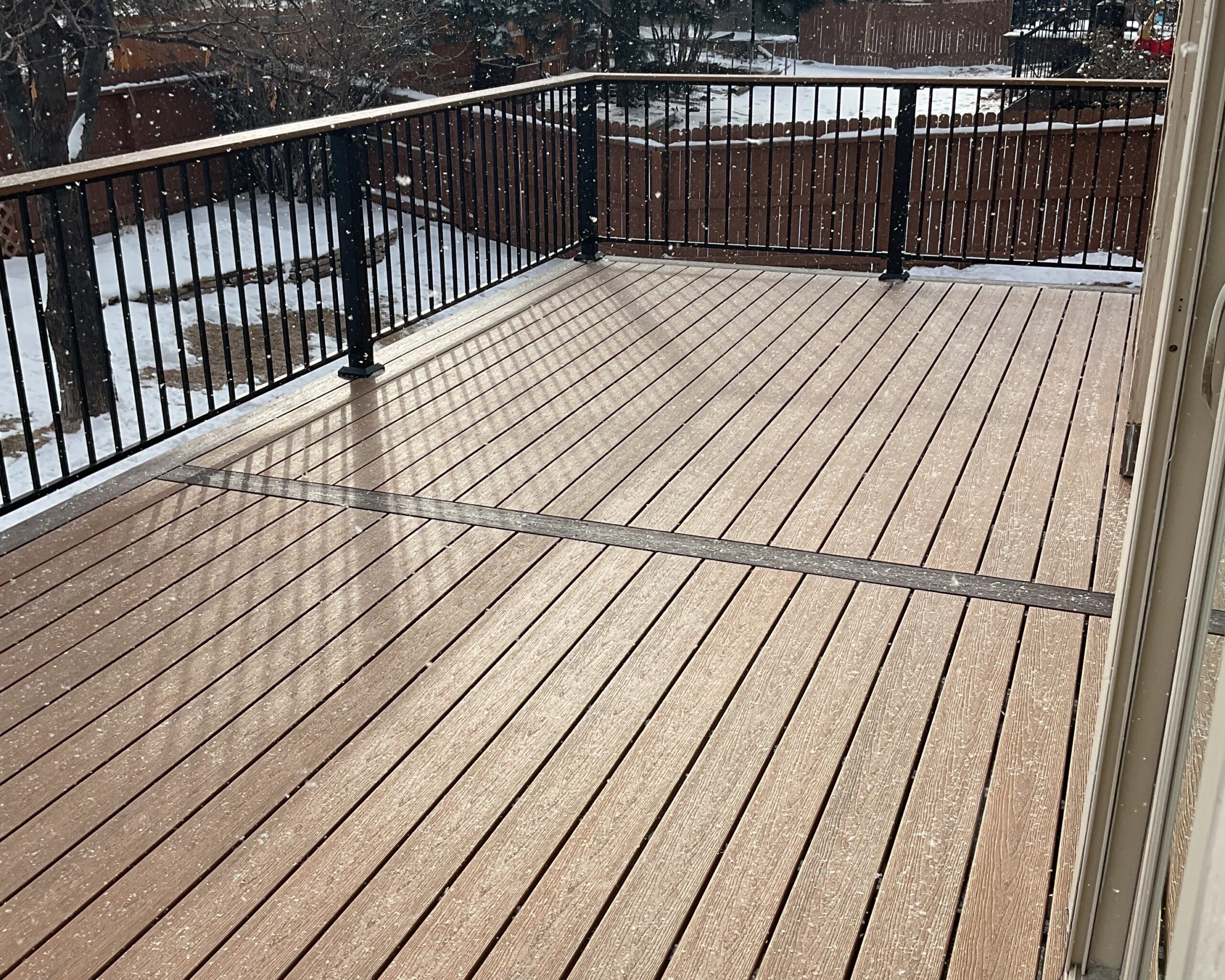 Composite deck with dividing and end boards and Fortress black metal railing