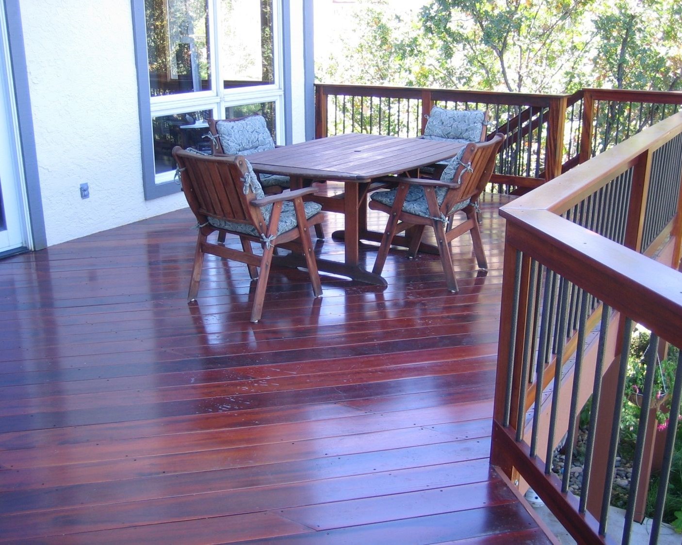 Tigerwood hardwood deck with railing featuring round metal balusters and a Tigerwood drink cap.
