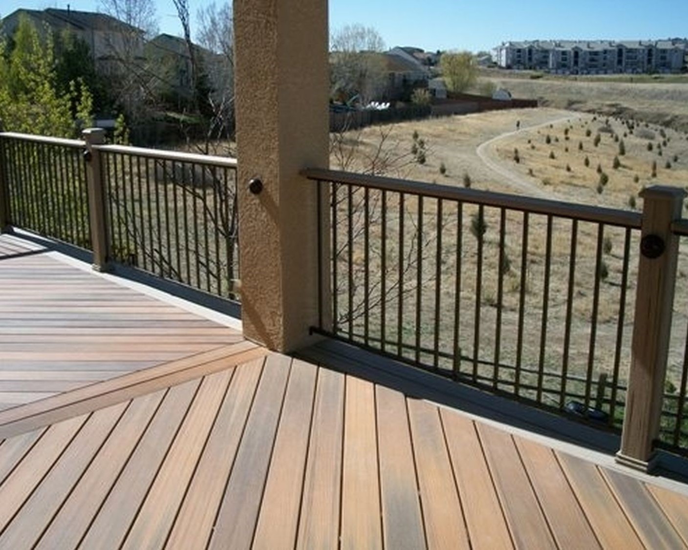 Elevated composite deck with a herringbone design and double divider board. There is also a double picture frame border in a contrasting color.