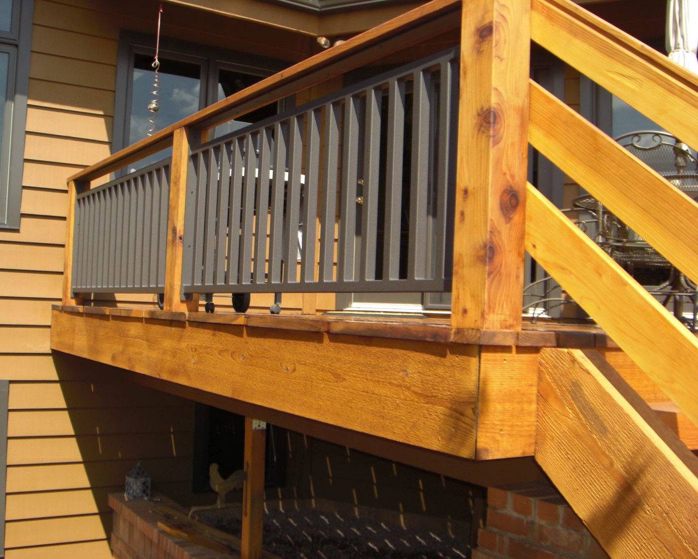 Redwood deck railing posts and drink cap with a metal panel installed between the posts.