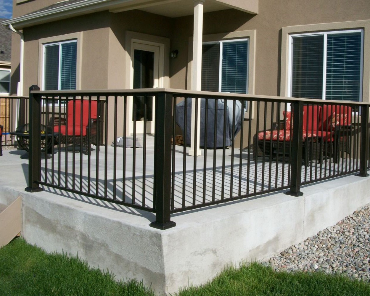 Fortress Fe26 panel railing installed on a concrete patio with a composite flush drink cap.