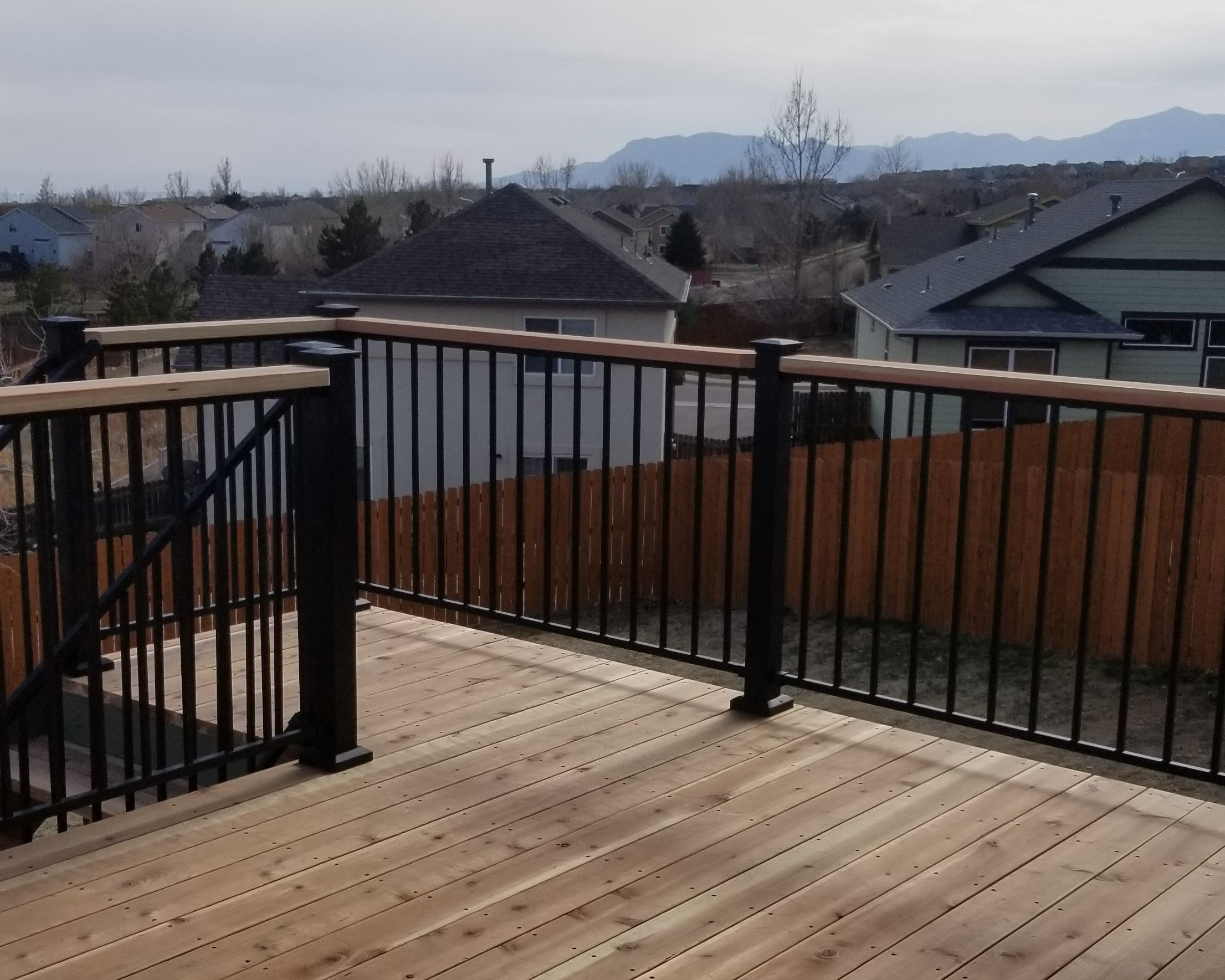 Redwood deck with a Fortress Fe26 metal panel railing system and a wood drink cap.