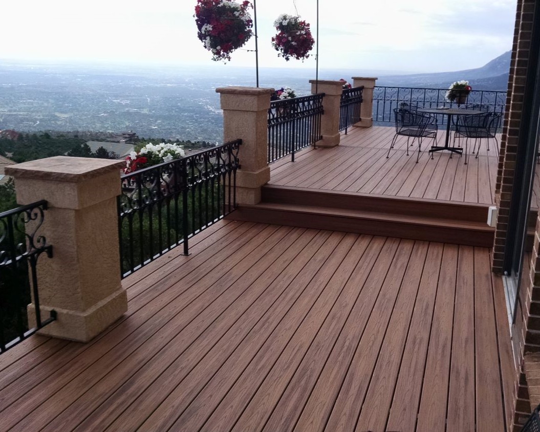 Multi-level composite deck with a custom designed and built wrought iron railing provides an area to entertain overlooking the city of Colorado Springs.