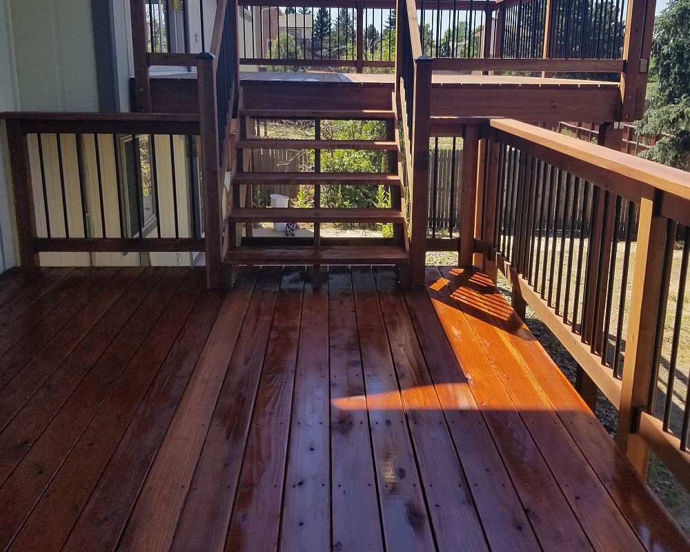 Two wood decks at different heights but attached by a set of stairs.