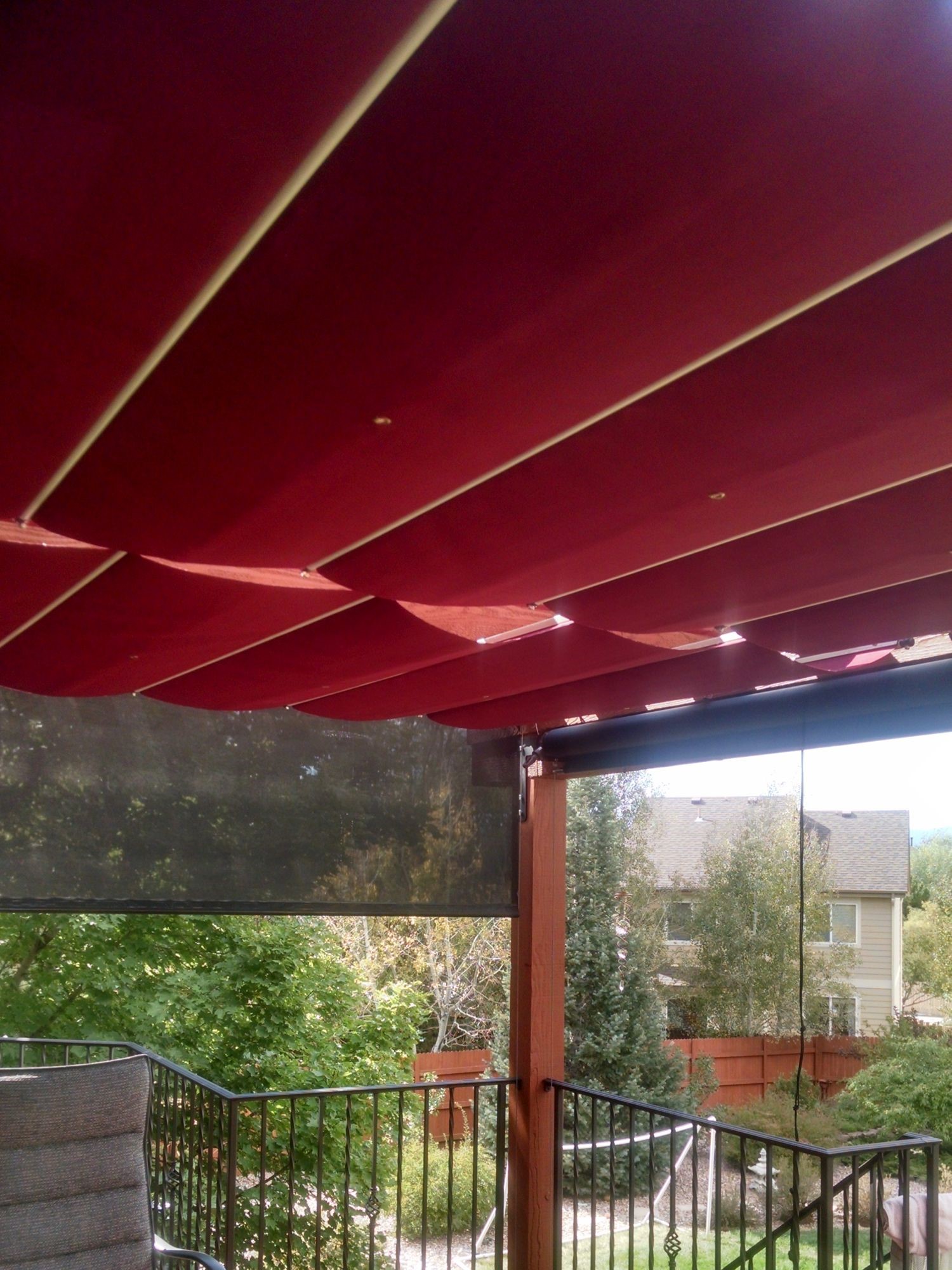 Pergola with sliding shades along the top to provide full shade when desired.