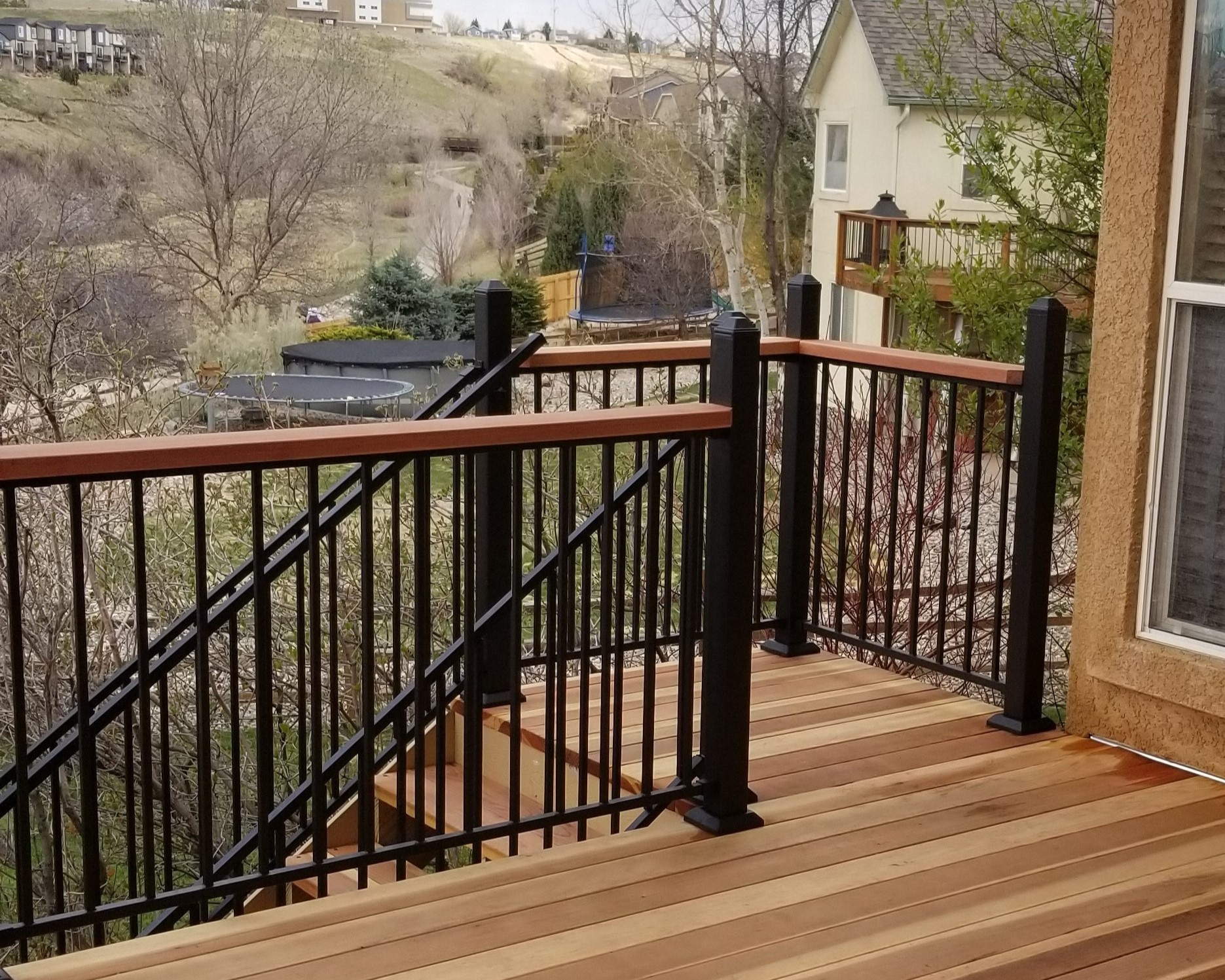 Metal panel deck railing with raised posts and redwood drink cap.