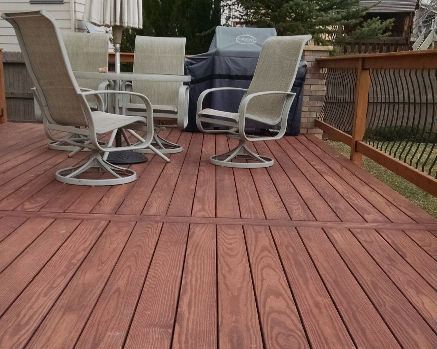 Redwood deck with the boards laid at 90-degrees. The railing features Vienna style balusters which bow out a little