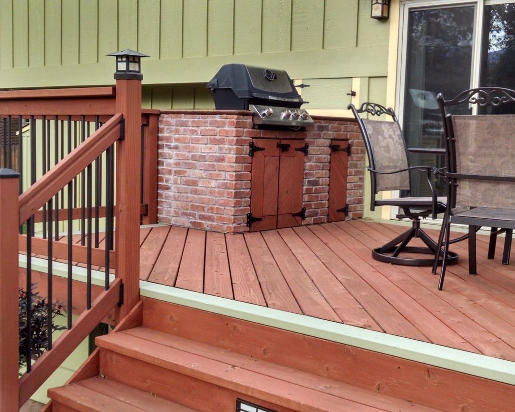 Redwood deck with a single picture frame border that is stained in a contrasting color. We also built a brick grill area with storage below.