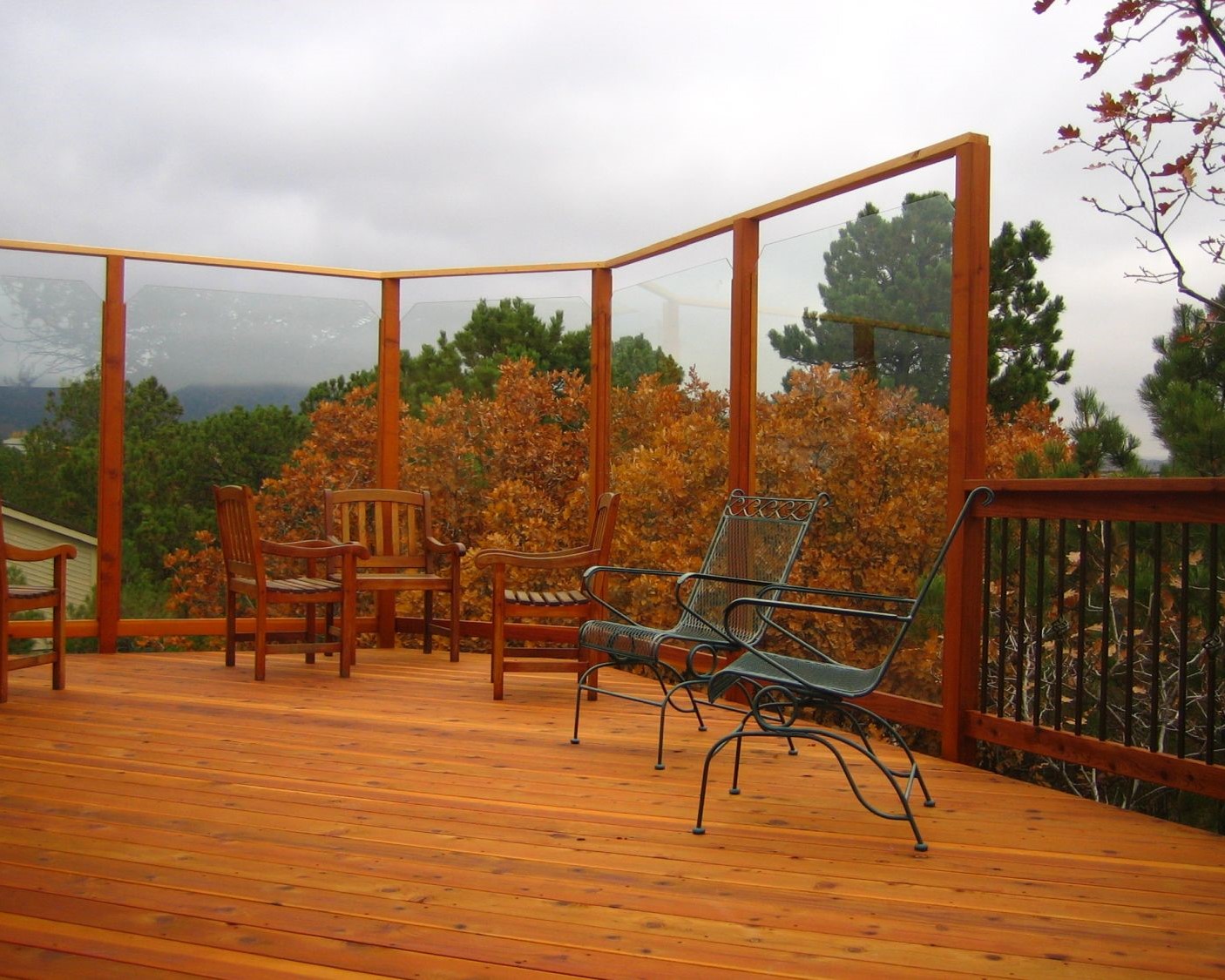 Custom designed Redwood deck with large glass wind breaks installed on end of deck.