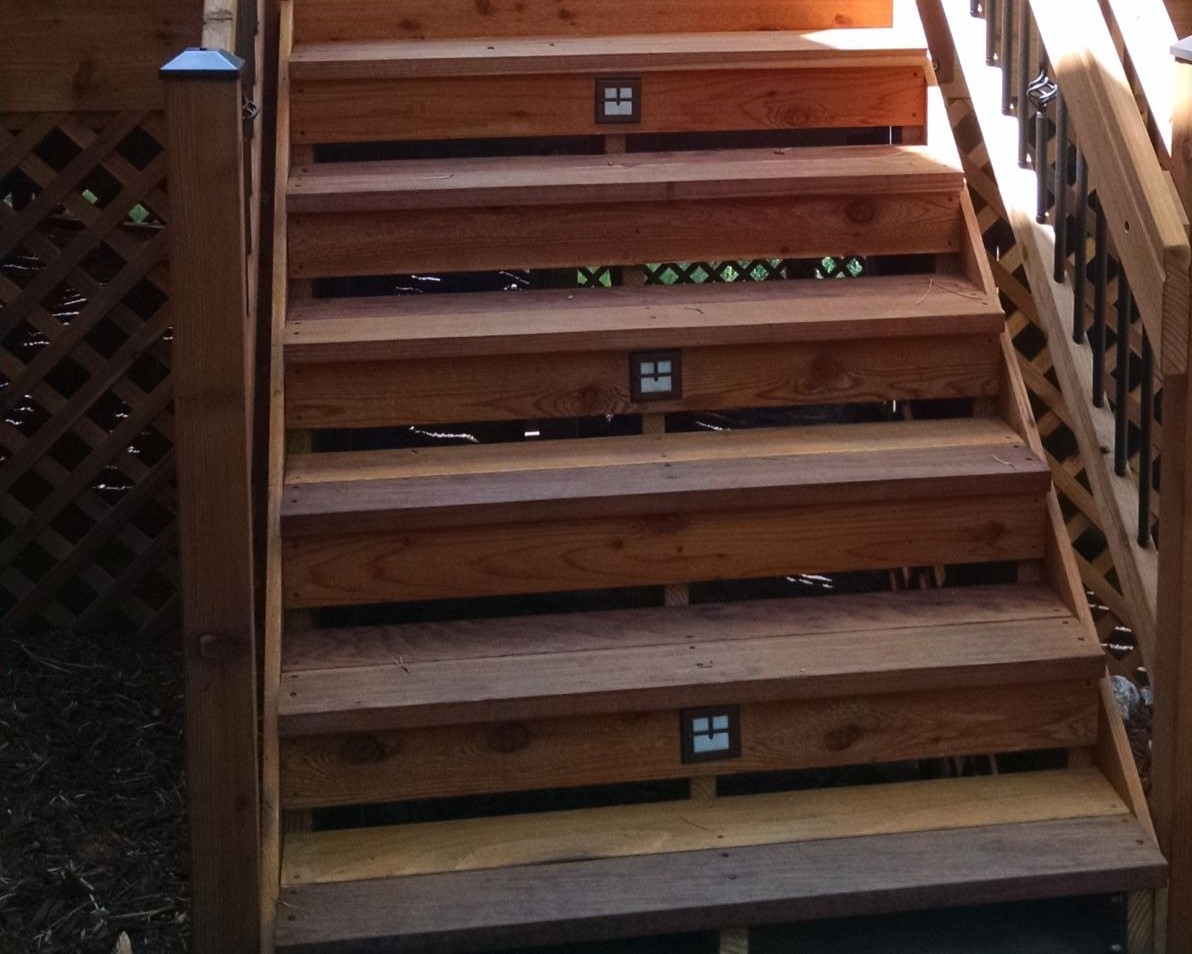 Redwood deck with partially closed stairs and step lights.