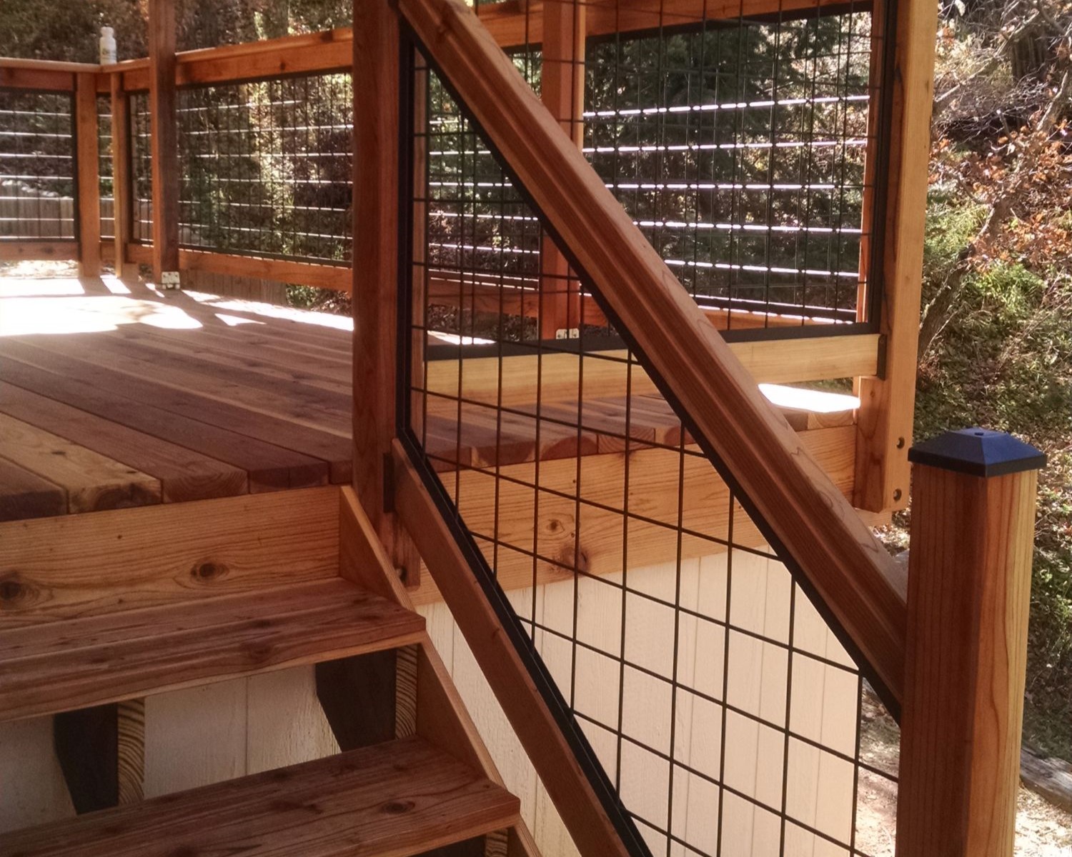 Redwood deck with a Wild Hog railing. The grid design panels are installed between the posts.