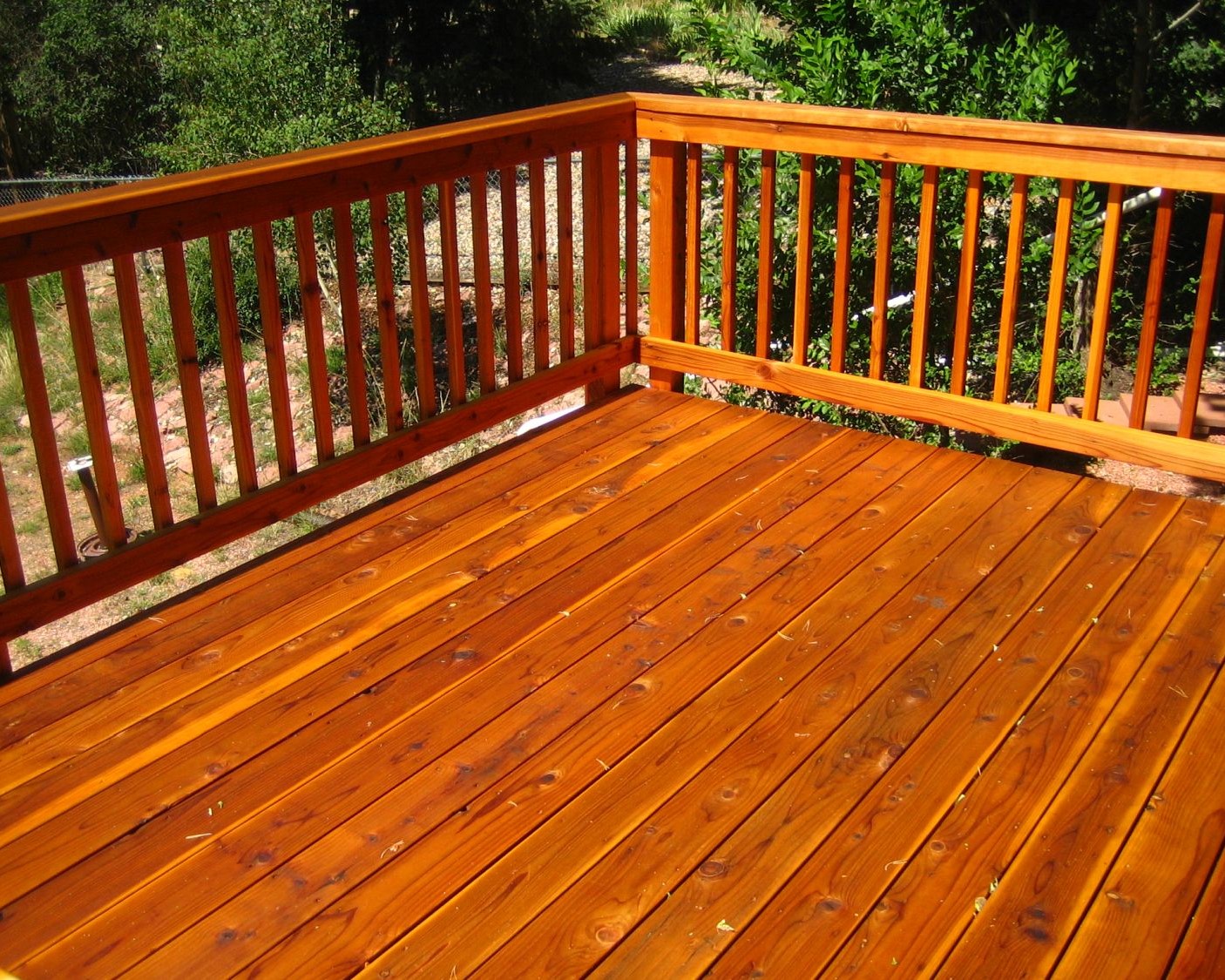 Beautiful redwood deck with a snow fence railing featuring a drink cap