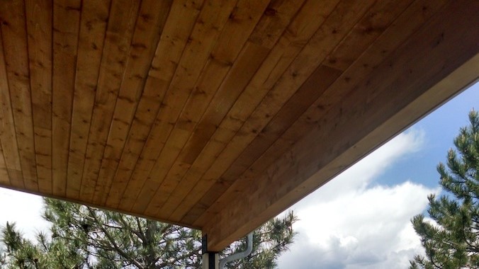 View from underneath of a shed roof deck cover with a tongue and groove Knotty Pine ceiling.