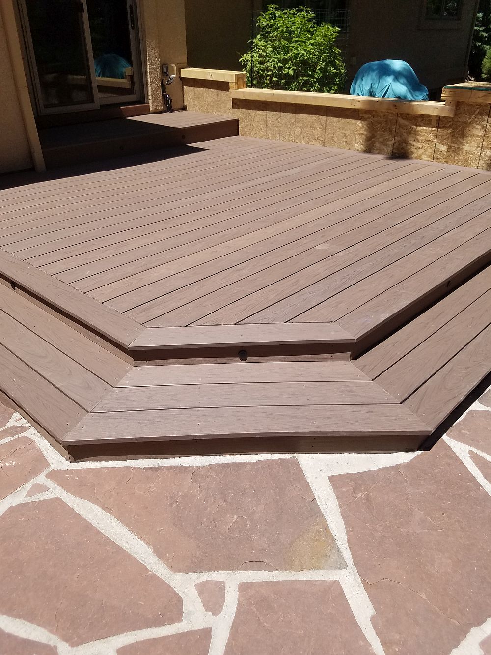 A ground level composite deck that features a single wrap around stair.