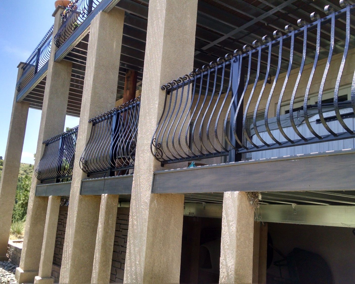 Two elevated, composite decks that were built with a wrought iron railing that has Vienna style balusters.