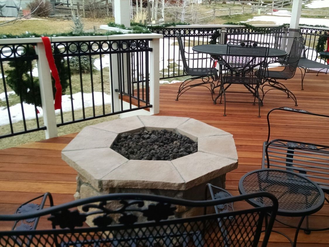 Custom redwood deck with multiple seating areas, one of which includes a stone firepit.
