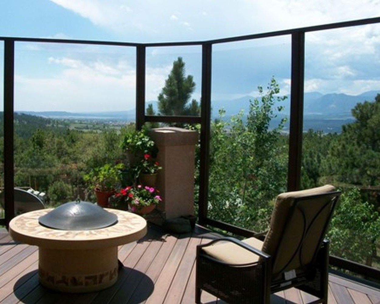 Composite deck with a beautiful view of the hills and Colorado Springs. It has a glass windbreak and fire pit.