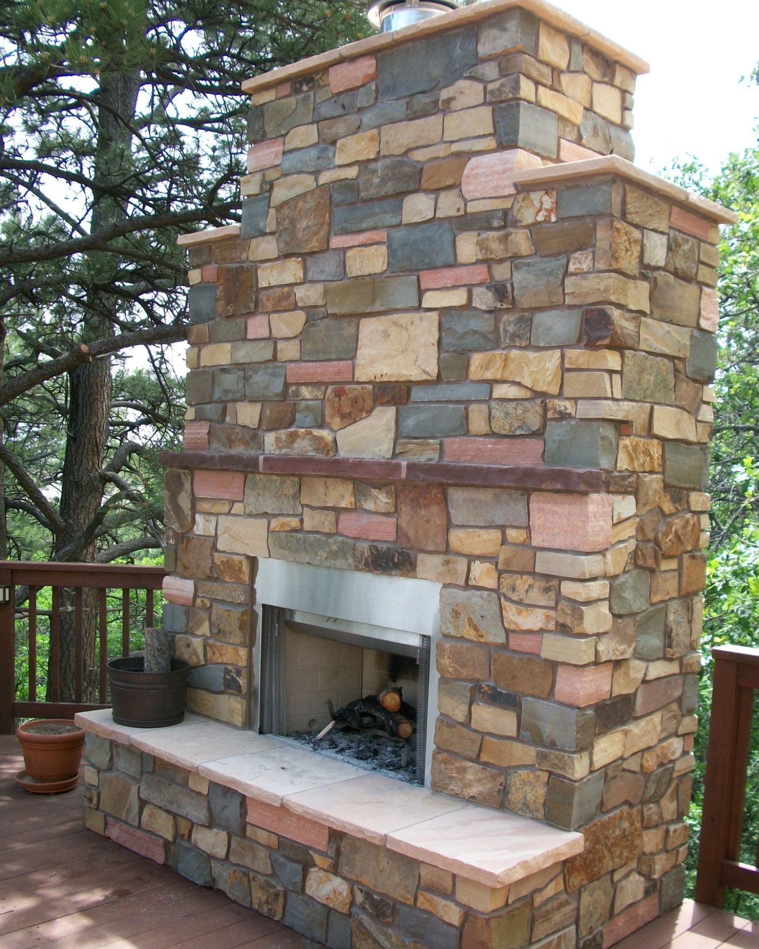 Redwood deck with a stone, wood-burning fireplace.